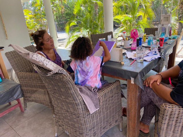 Marieke geeft een kind tekenles op Bonaire